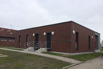 Die Rückseite eines kleinen kastigen Gebäudes mit zwei Treppenaufgängen