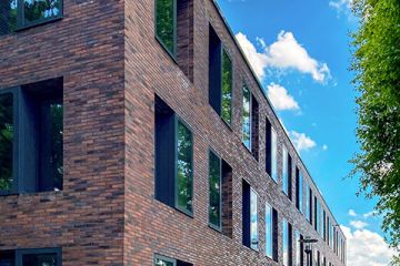 Rückseite eines modernen Gebäudes mit schwarzen Fenstern