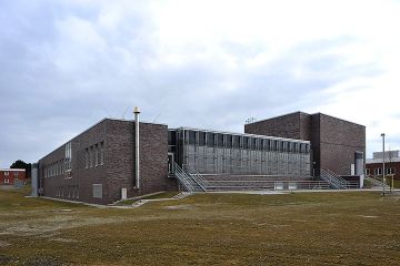 Ein Gebäude mit modernen, dunklen Ziegelsteinen und einer gläsernen Front