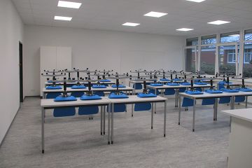 Steriler Chemieraum der OBS Hohenkirchen mit leuchtend blauen Drehstühlen