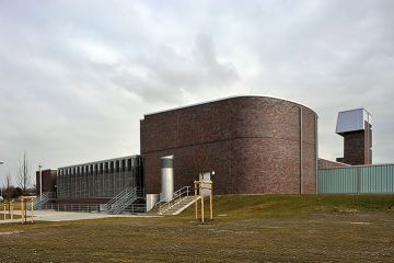 Ein Gebäude mit modernen, dunklen Ziegelsteinen und einer abgerundeten Ecke