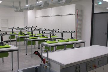 Steriler, heller Chemieraum der OBS Hohenkirchen mit saftig grünen Drehstühlen an den Sitzplätzen